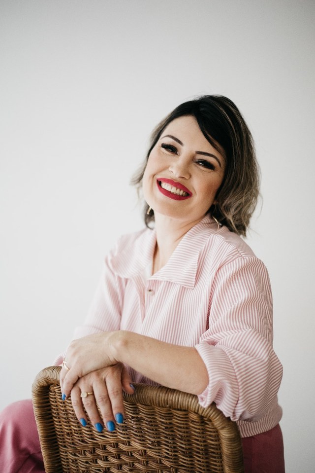 Fabiana Vicente Duarte sorrindo, apoiada em uma cadeira