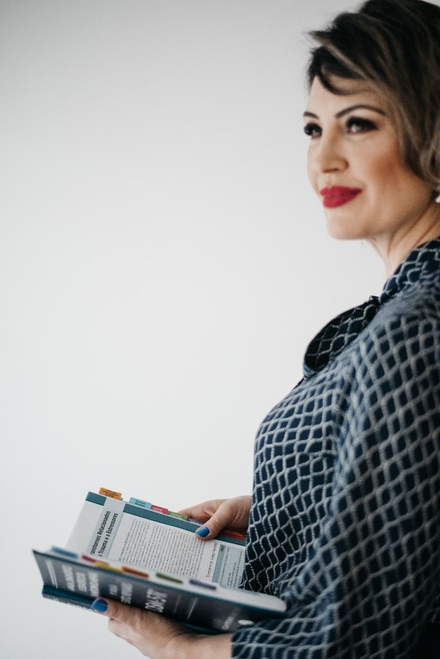 Fabiana Vicente Duarte segurando um livro de estudo